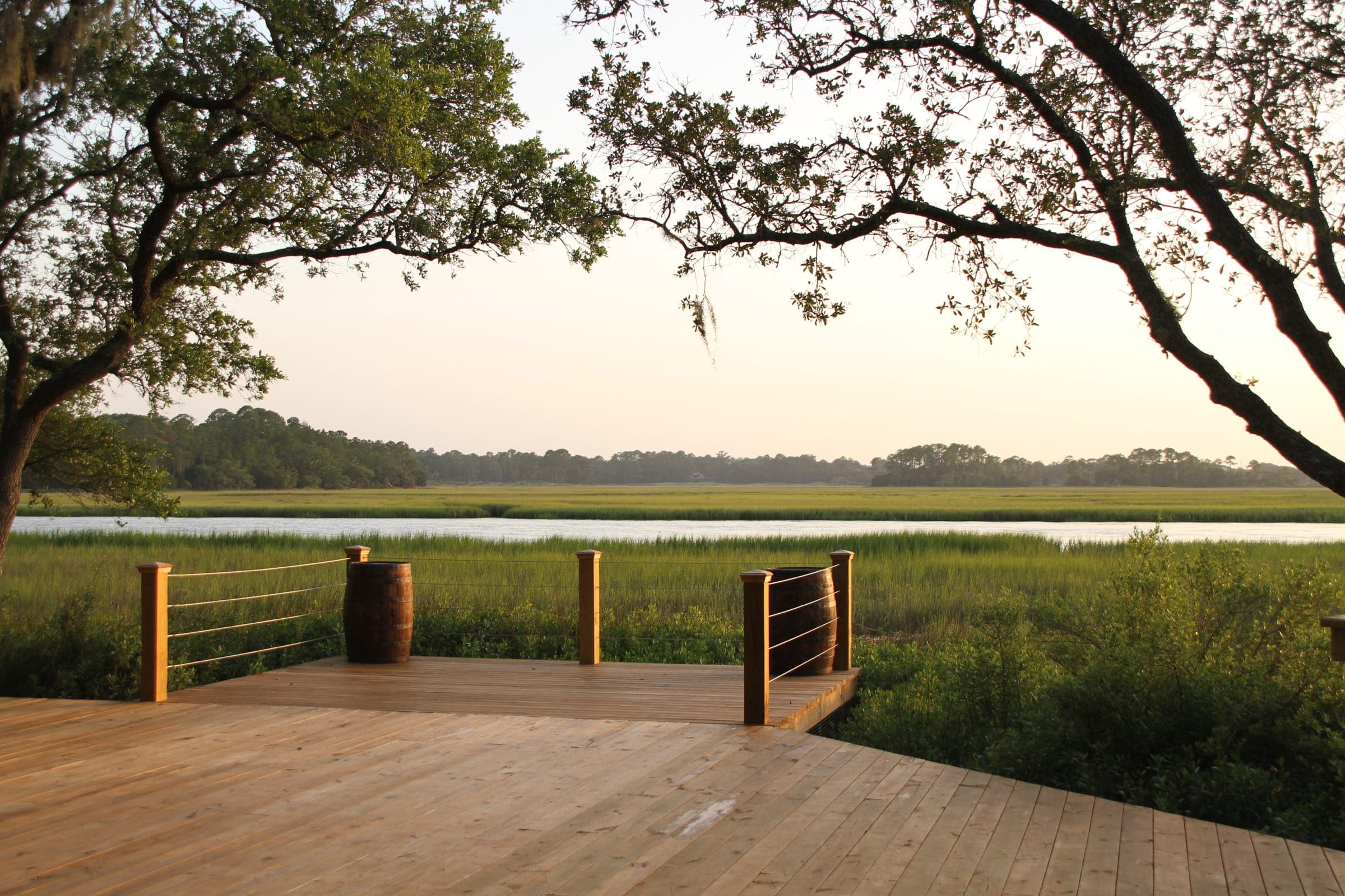 Wooden deck under live oak limbs looking across the marsh at Mingo Point, Kiawah Island
